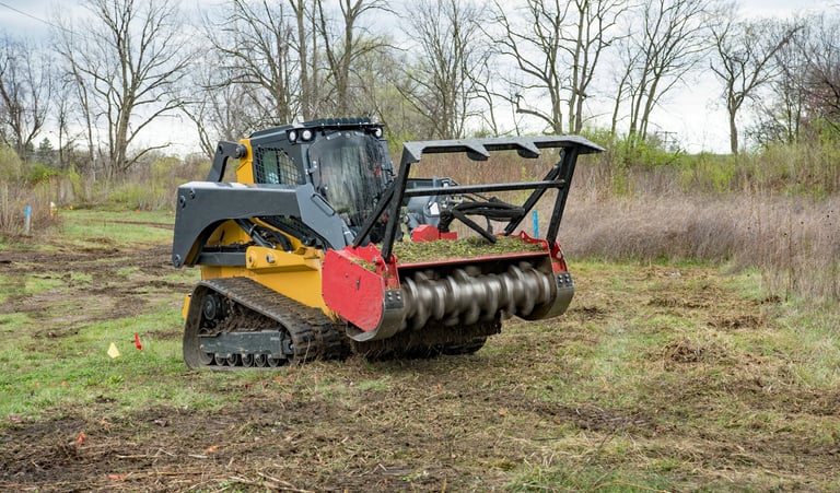 Forestry mulcher actively mulching weeds from field in preparation for new housing development